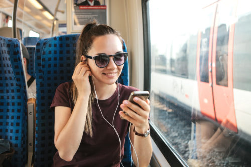 A Young Girl Listens To A Music Or Podcast While Traveling In A Train